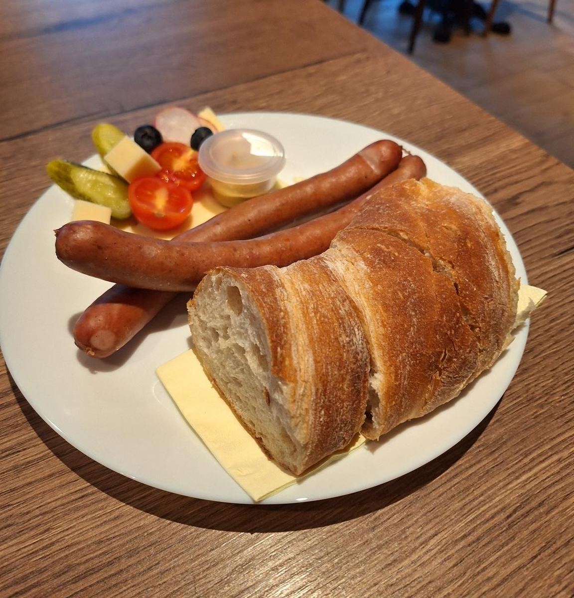 Schweinswürstli mit Brot, Senf und Garnitur